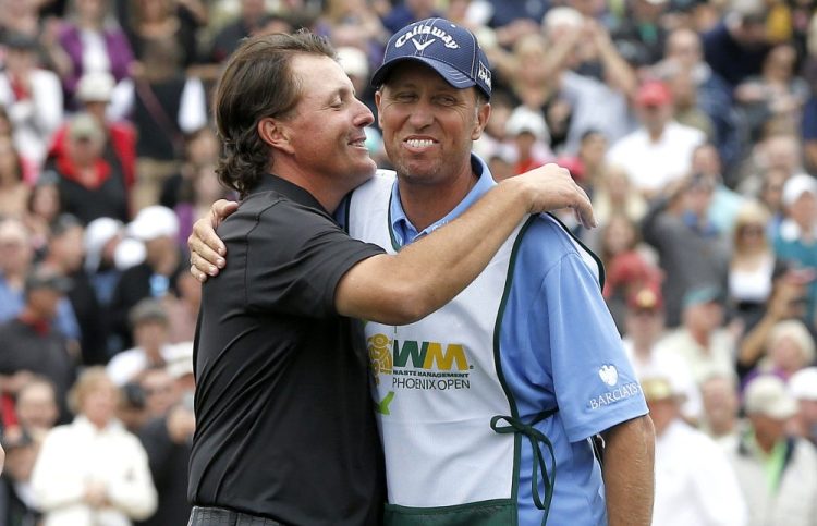 Phil Mickelson, left, hugs his caddie, Jim Mackay, after winning the Phoenix Open in 2013. Mickelson and Mackay have decided to part ways after 25 years of one of the PGA's most famous player-caddie relationships.