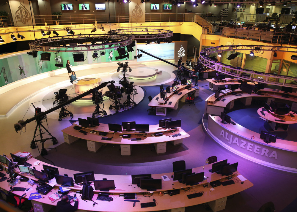 Members of Al-Jazeera International work at the news studio in Doha, Qatar. Saudi Arabia and other Arab nations are demanding that Qatar shut down Al-Jazeera.