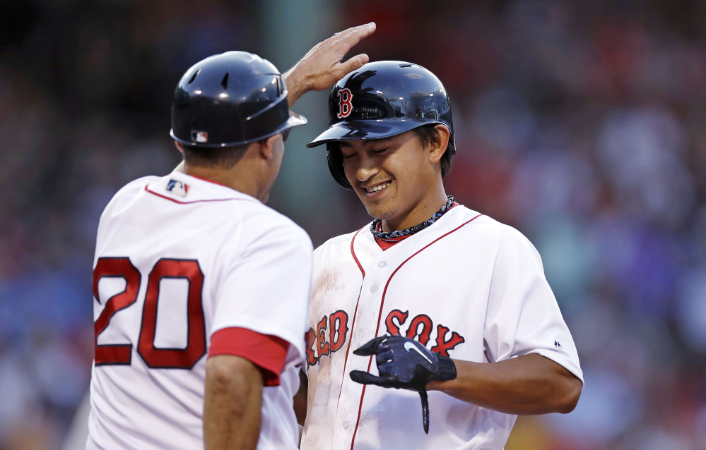 Red Sox rookie Tzu-Wei Lin gets a congratulatory tap on the helmet by first base coach Ruben Amaro Jr. after his first major league hit, a single in the second inning.