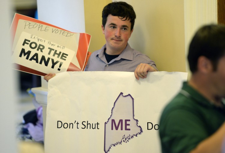 Nate LeClair of Auburn spreads his message opposing a government shutdown Tuesday at the State House. A closure would affect many of the state's more than 10,000 employees.