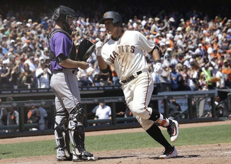Giants rookie Jae-Gyun Hwang, called up before Wednesday's game to make his big league debut, crosses the plate after hitting a go-ahead homer in the sixth inning against Colorado.