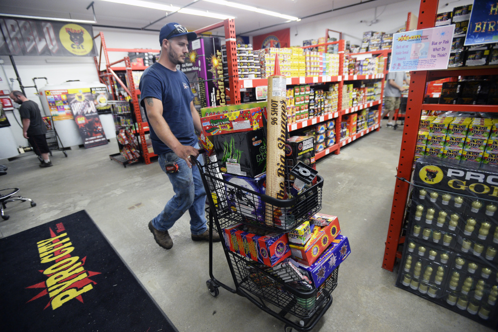 Tom Craves of Windham pushes a cart full of fireworks while shopping at Pyro City Fireworks in Windham on Friday.