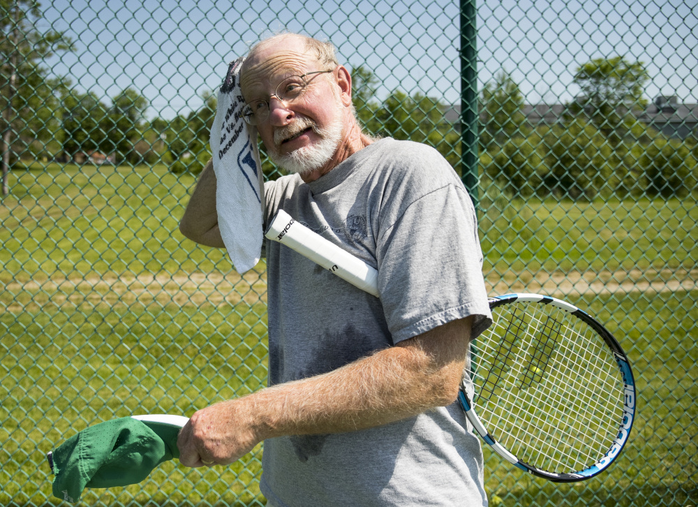 Doug Legg, of Waterville, pauses to towel off sweat during a doubles tennis match with friends at the tennis courts on Capitol Street in Augusta on Monday.