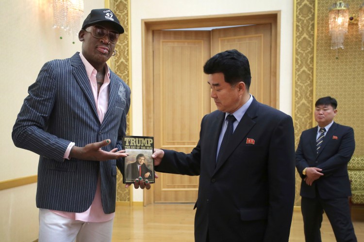 Former NBA star Dennis Rodman presents Donald Trump's book "The Art of the Deal" to North Korean Sports Minister Kim Il Guk on Thursday in Pyongyang, North Korea. 