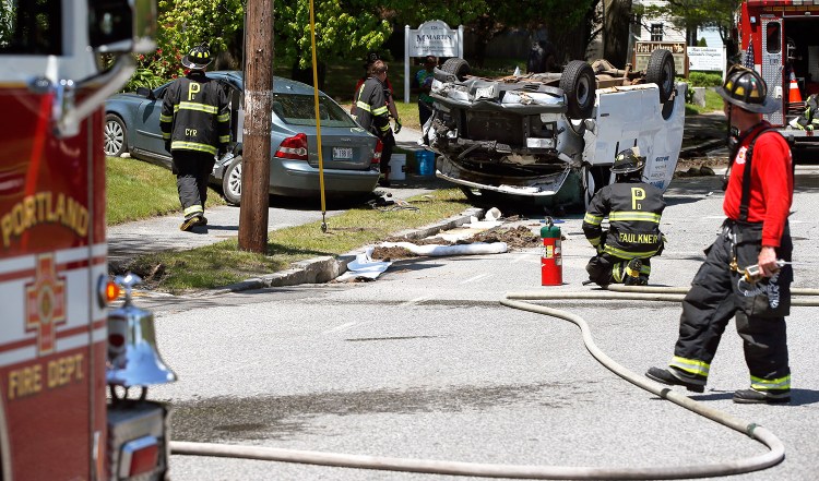 Firefighters clear the scene of a two-vehicle collision in the North Deering neighborhood of Portland on Thursday. Several blocks of Auburn Street were closed near Northgate Plaza.