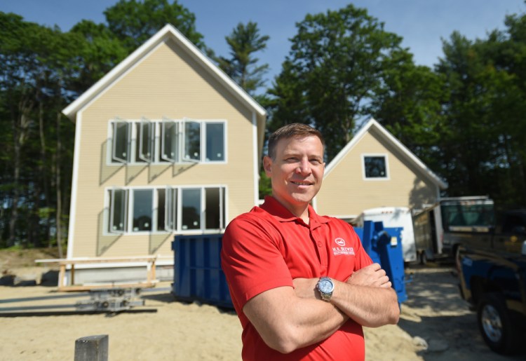 Builder Matt Brewer in front a a custom energy-efficient home in Village Run, a new subdivision in Yarmouth originally envisioned as a neighborhood of modular, high-performance homes.
