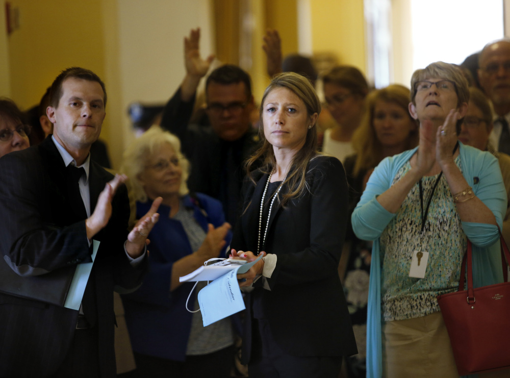 AUGUSTA, ME - JULY 1: House Majority Leader Erin Herbig and House Assistant Majority Leader Jared Golden, left, are met by applause at the State House by dozens of state workers on Saturday, July 1, 2017, the first day of Maine's government shutdown following a a budget impasse that has yet to be resolved. (Staff photo by Derek Davis/Staff Photographer)