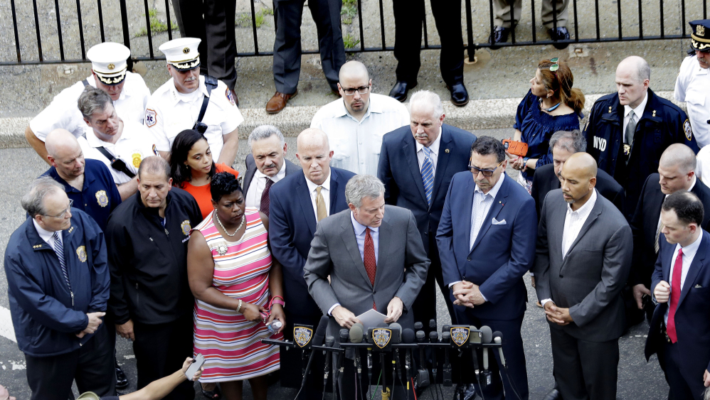 New York Mayor Bill De Blasio, center, speaks outside of the Bronx Lebanon Hospital Center in New York on Friday after a shooter killed one and wounded six.