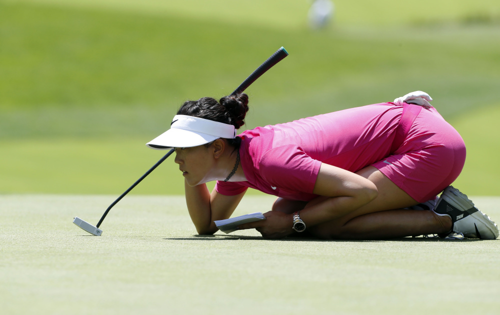 Michelle Wie reads the fifth green – as well as her notes – while lining up her putt during the third round of the KPMG Women's PGA Championship on Saturday afternoon. Wie is tied for seventh at 5 under, four shots off the lead.