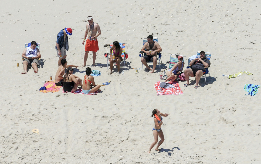 New Jersey Gov. Chris Christie, right, uses the beach with his family and friends at the governor's summer house at Island Beach State Park on Sunday. Christie is defending his use of the beach, which was closed to the public.