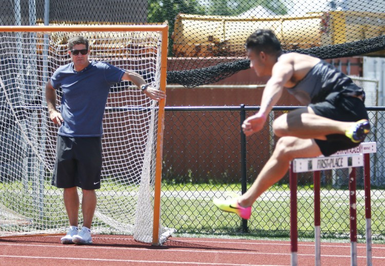Former Kennebunk High track star Jamie Cook watches as Devon Allen works out Monday at Thornton Academy in Saco. Cook, a former assistant coach at the University of Oregon, brought Allen and Johnathan Cabral to Maine for a workout in front of high school athletes and coaches.
