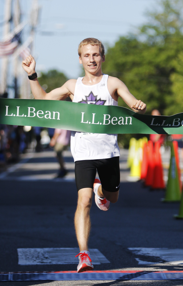 Ryan Smith of Farmington crosses the finish line to win the L.L. Bean Fourth of July 10K on Tuesday in Freeport. Smith finished in 32:31.