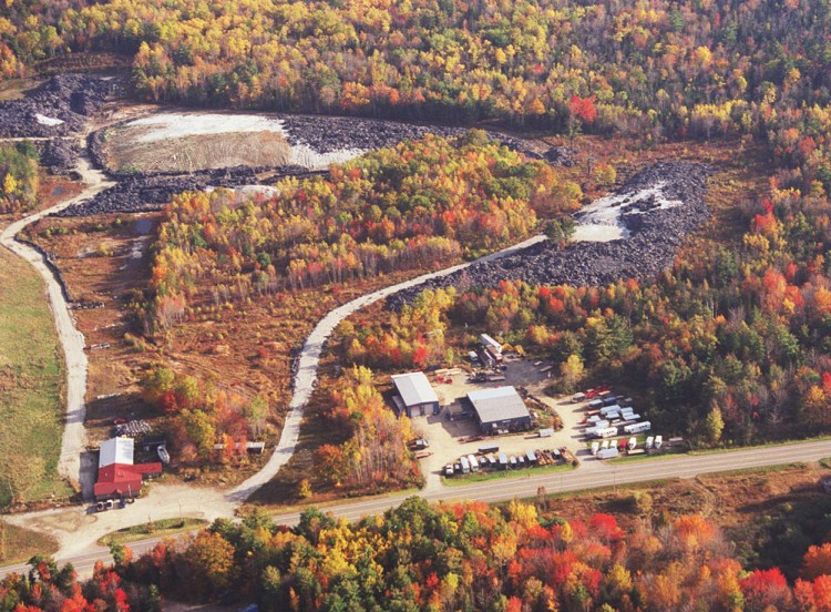 A 2001 aerial photo shows fiber material waste in Warren, with Route 90 in the foreground. Only 1,000 of the 27,000 tons of waste have been removed under a contract that expired in April, and "people are frustrated, aggravated."