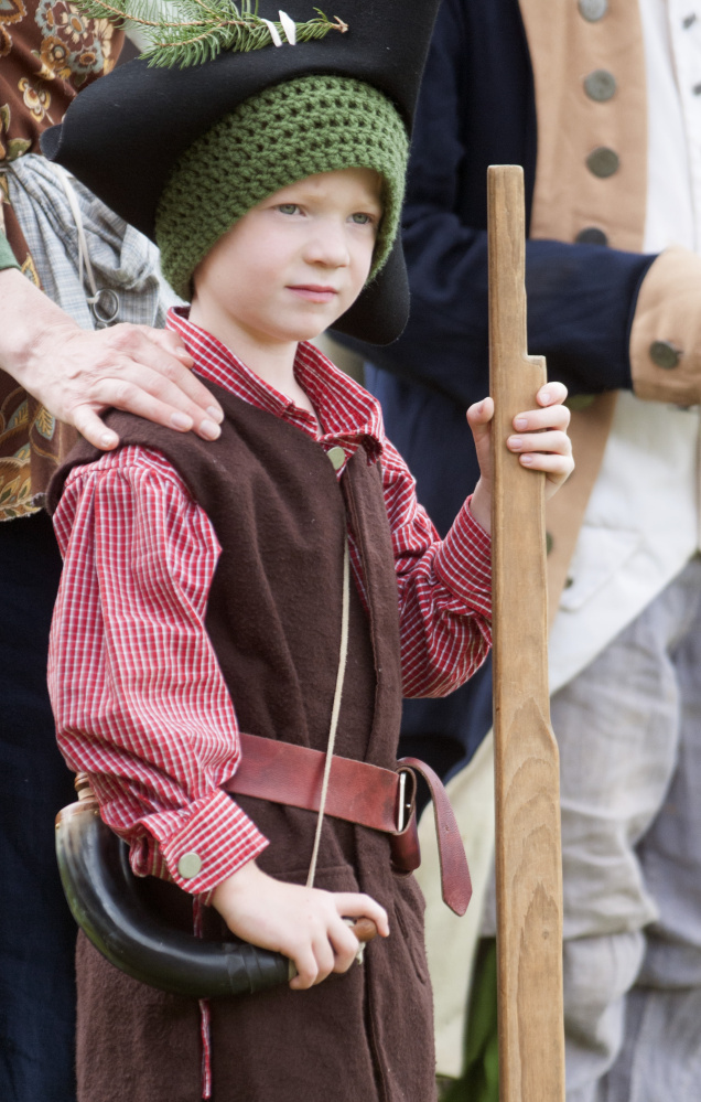 Re-enactor Benjamin Bickford, 4, of Oakland, stands with his mother, Eileen Bickford, and other re-enactors during a ceremony Tuesday at Old Fort Western in Augusta.