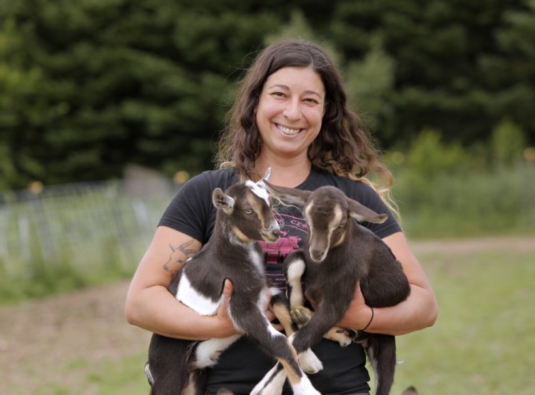 Jessie Dowling holds baby goats at her Whitefield farm.