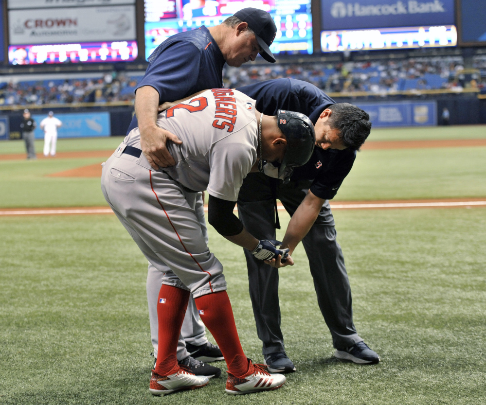 Boston Red Sox Manager John Farrell, left and assistant athletic trainer Masai Takahashi, right, check on Xander Bogaerts after he was hit in the hand by a pitch from Tampa Bay pitcherJake Faria in the first inning on Thursday. X-rays were negative on Boegarts, who left the game after getting hit. Tampa Bay won the game, 4-1. (Associated Press/Steve Nesius)