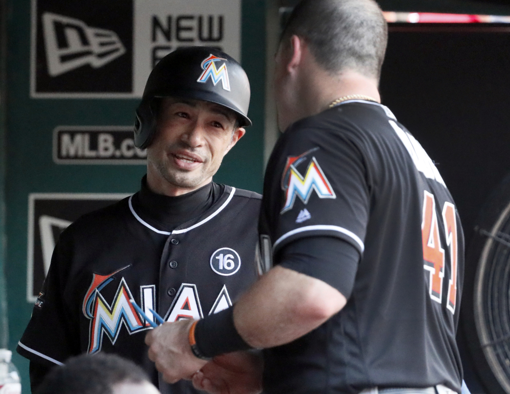 Ichiro Suzuki, left, of the Miami Marlins talks with teammate Justin Bour after becoming the career hits leader for foreign-born players during a 4-3 loss to the St. Louis Cardinals.