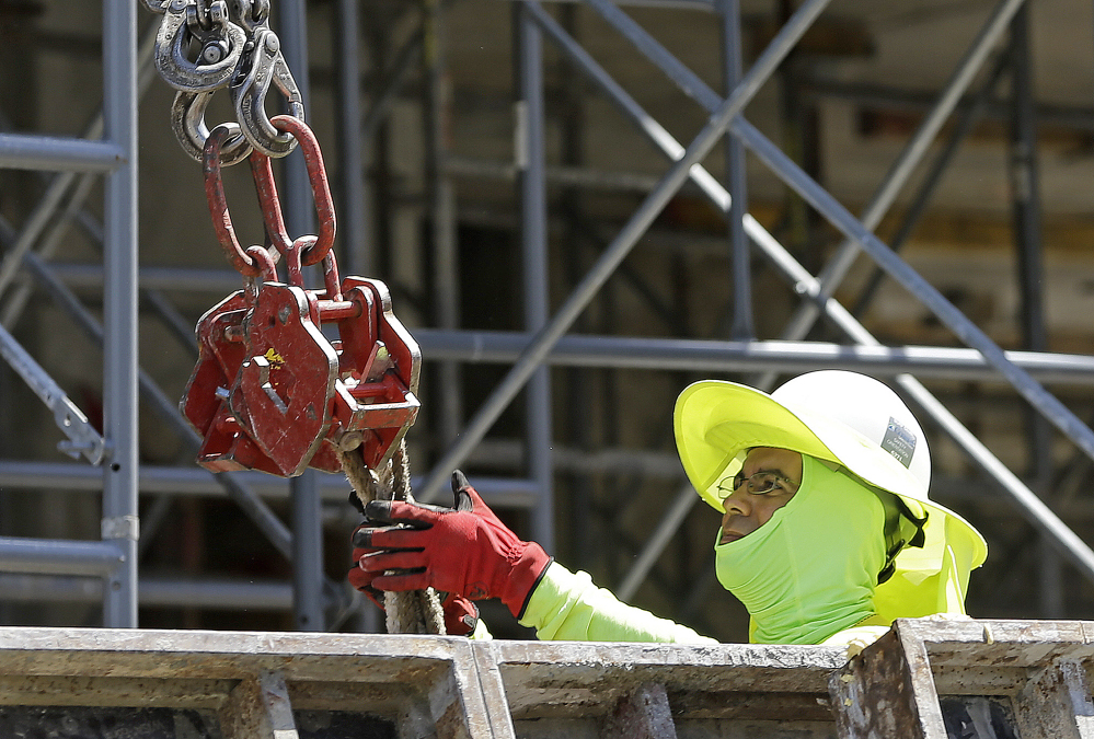 A construction worker works on a condominium project in Coral Gables, Fla. The Labor Department report for June shows the most jobs growth in four months.