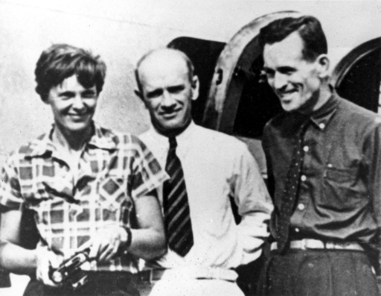 Amelia Earhart, left, and her navigator, Fred Noonan, right, pose beside their plane with gold miner F.C. Jacobs at Lae, New Guinea just before Earhart and Noonan took off on their final fateful flight.