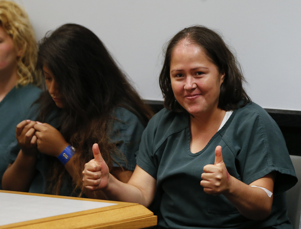 Isabel Martinez gestures toward news cameras during her first court appearance Friday in Lawrenceville, Ga. Martinez is charged with killing four of her children and their father.