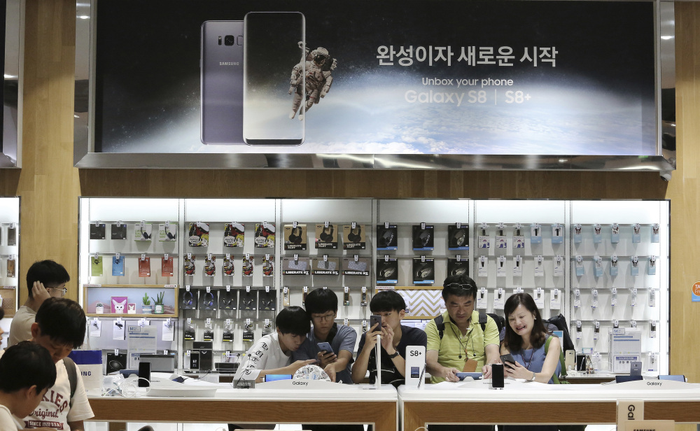 Visitors experience the Samsung Electronics Galaxy S8 Plus smartphone at one of the company's stores in Seoul, South Korea. The tech company said Friday its second-quarter operating profit soared to the highest in its history.