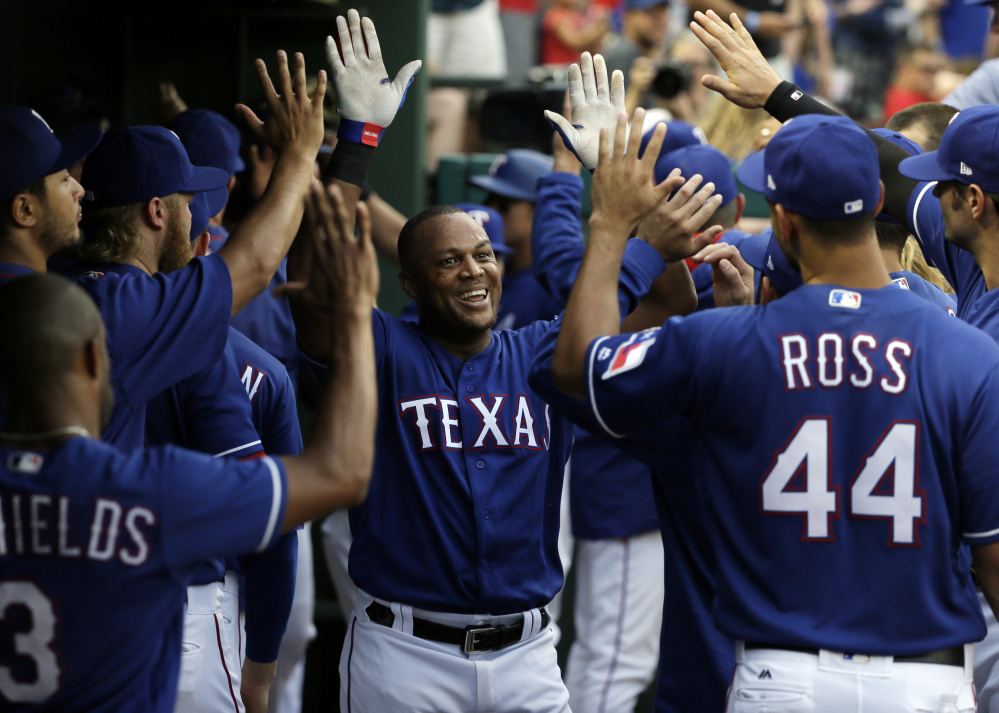 Texas Rangers' Adrian Beltre, center, is congratulated in the dugout after hitting a three-run home run off Los Angeles Angels starting pitcher Ricky Nolasco in the second inning Friday in Arlington, Texas. The hit was Beltre's 2977th career hit. 