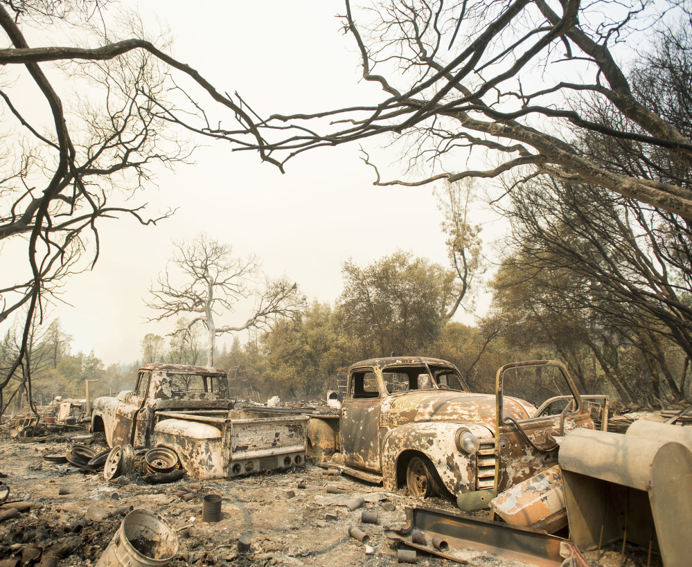A wildfire left vintage trucks burned near Oroville, Calif., on Saturday. The fire south of Oroville was one of more than a dozen burning around the state in scorching temperatures.