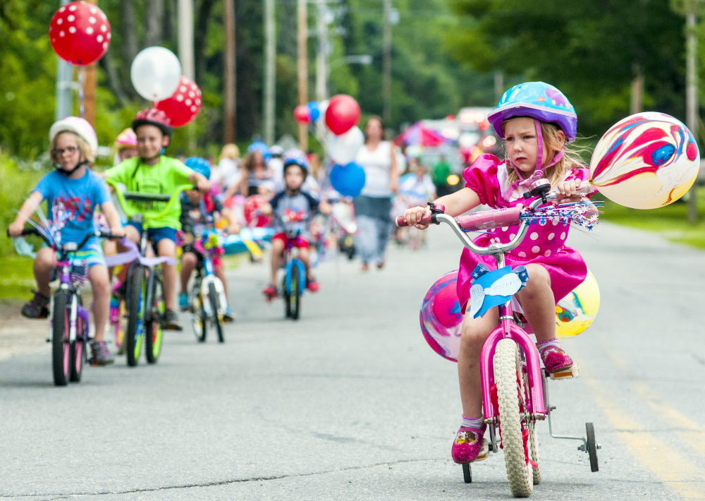 Alice Lazure, 4, seems to concentrate hard as she rides her bike in the town's parade on Saturday in Monmouth.