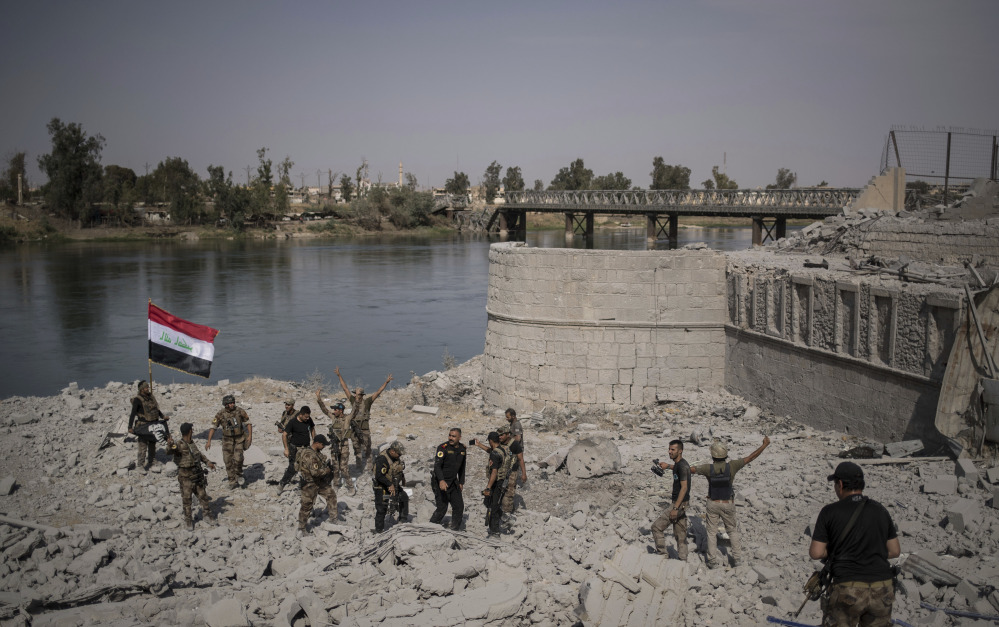 Iraqi soldiers celebrate after reaching the bank of the Tigris River in their fight against Islamic State militants in Mosul.