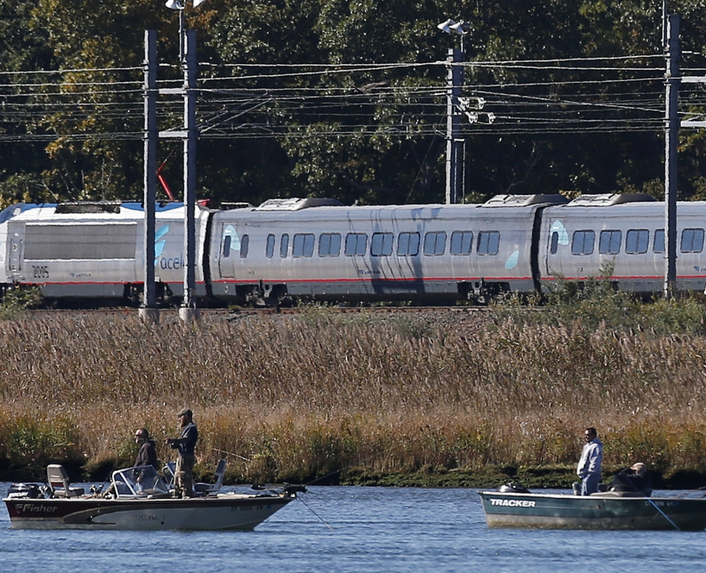 An Amtrak train travels along the shore in Old Saybrook, Conn. Foes said a planned rail bypass would devastate neighborhoods, marshlands and tourist attractions.