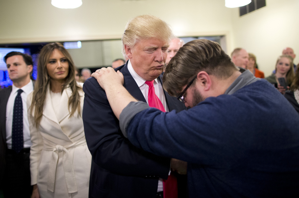 A Catholic media outlet has come under criticism in a Vatican-approved article that said it framed Donald Trump's ascent to the presidency as "a divine election." Here, a pastor prays for then-candidate Trump in an Iowa church.
, as wife, Melania, left, watches after a Sunday service at First Christian Church, in Council Bluffs, Iowa. The list of prominent evangelicals denouncing Trump is growing, but is anyone in the flock listening?  The bloc of voters powering the real estate mogul through the Republican primaries is significantly weighted with white born-again Christians. As Trump's ascendancy forces the GOP establishment to confront how it lost touch with so many conservative voters, top evangelicals are facing their own dark night, wondering what has drawn so many Christians to a twice-divorced, profane casino magnate with a muddled record on abortion and gay marriage.   (AP Photo