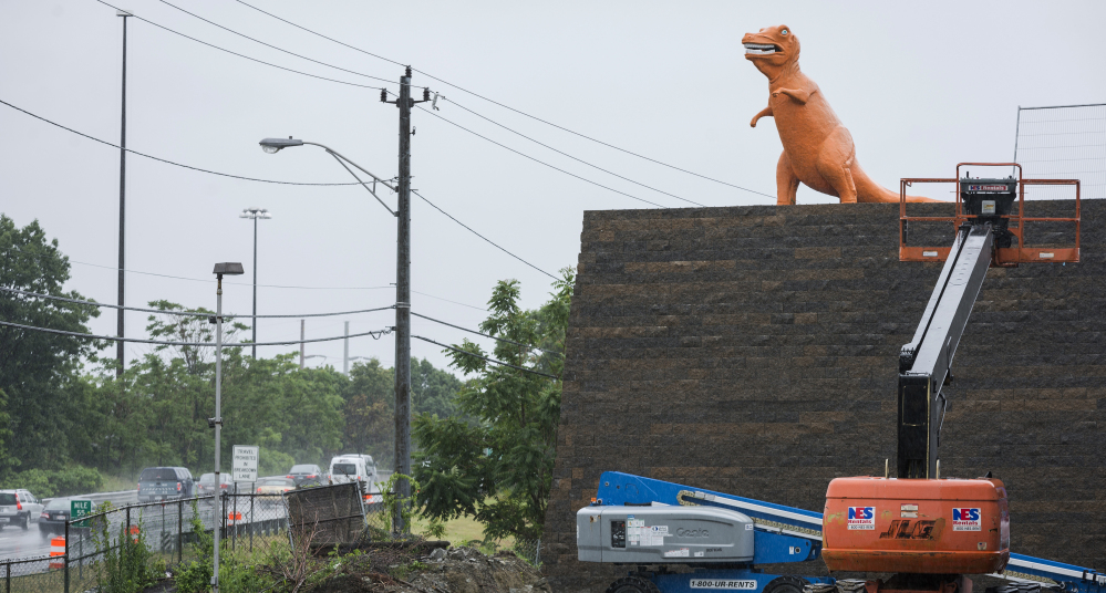 An orange dinosaur statue, a fixture on Route 1 in Saugus, Mass., for years, looks down from its new perch. The site it sits on was sold, but popular demand kept the dino from extinction.