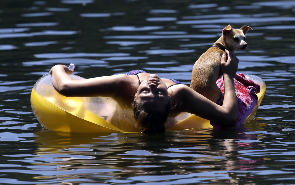 Justine Hicks floats with her dog, Kiana, on the Willamette River in Portland, Ore., in July 2015. The river once shunned by swimmers is enjoying a renaissance now that it's been cleaned up. The city is partnering with a civic group this summer to entice residents into the water.