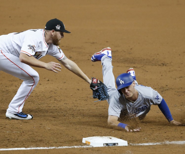 Miami pitcher Dan Straily tags out Cody Bellinger of the Los Angeles Dodgers, who was caught between first and second base in the third inning Friday night. The Dodgers won, 6-4.