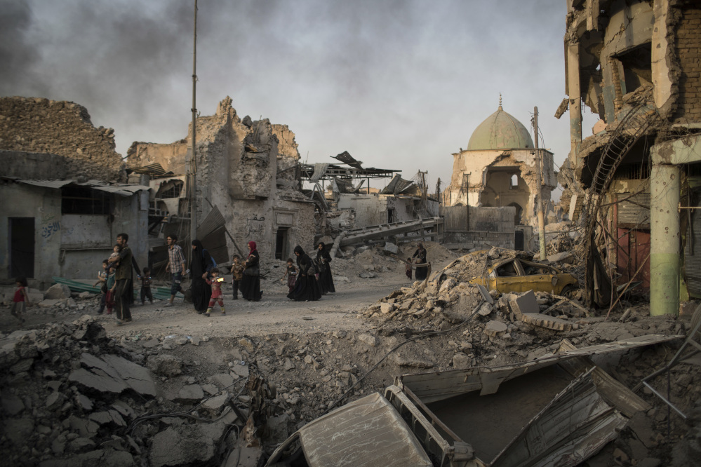 Fleeing Iraqi civilians walk past the heavily damaged al-Nuri mosque during fights between Iraqi security forces and Islamic State militants in the Old City of Mosul, Iraq, in early July.