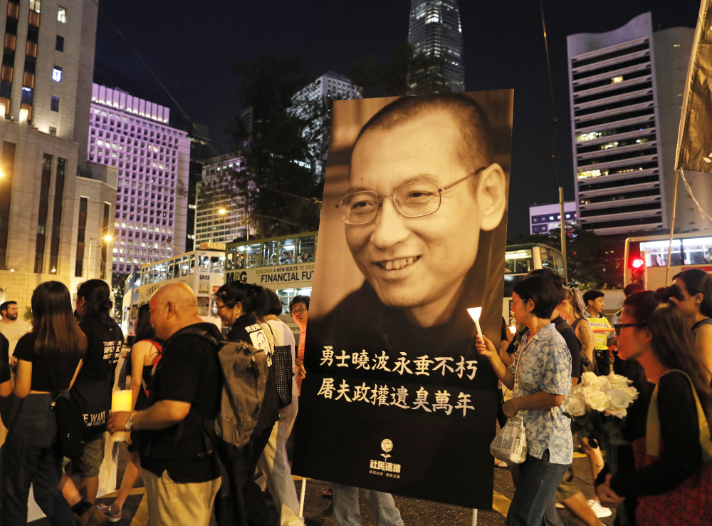 Protesters carry a picture of the late Chinese Nobel Peace laureate Liu Xiaobo as they march to mourn him in Hong Kong, on Saturday.
Associated Press/Vincent Yu