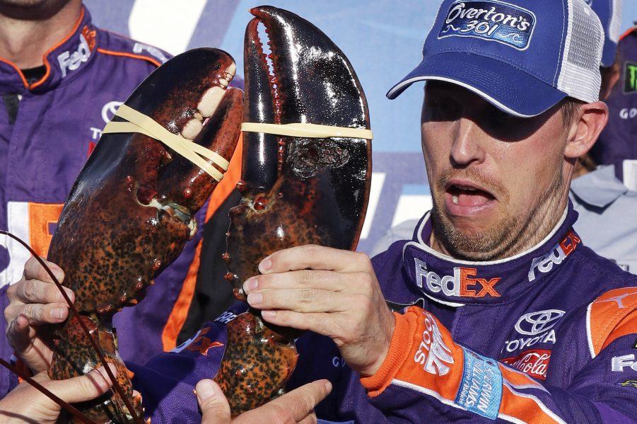 Driver Denny Hamlin reacts as he is handed a lobster after winning the NASCAR Cup Series 301 race at the New Hampshire Motor Speedway in Loudon on Sunday.
