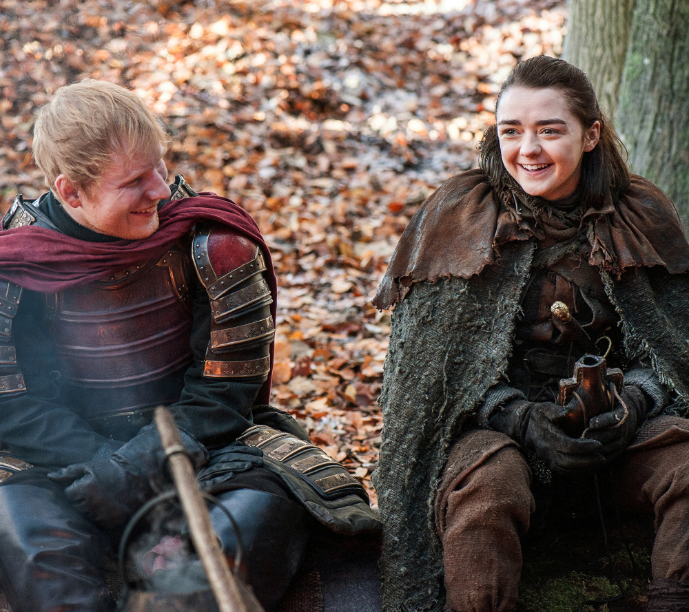 Ed Sheeran, left, and Maisie Williams appear in a scene from "Game of Thrones." Sheeran played a soldier leading a group in song in the season premiere of the HBO drama.