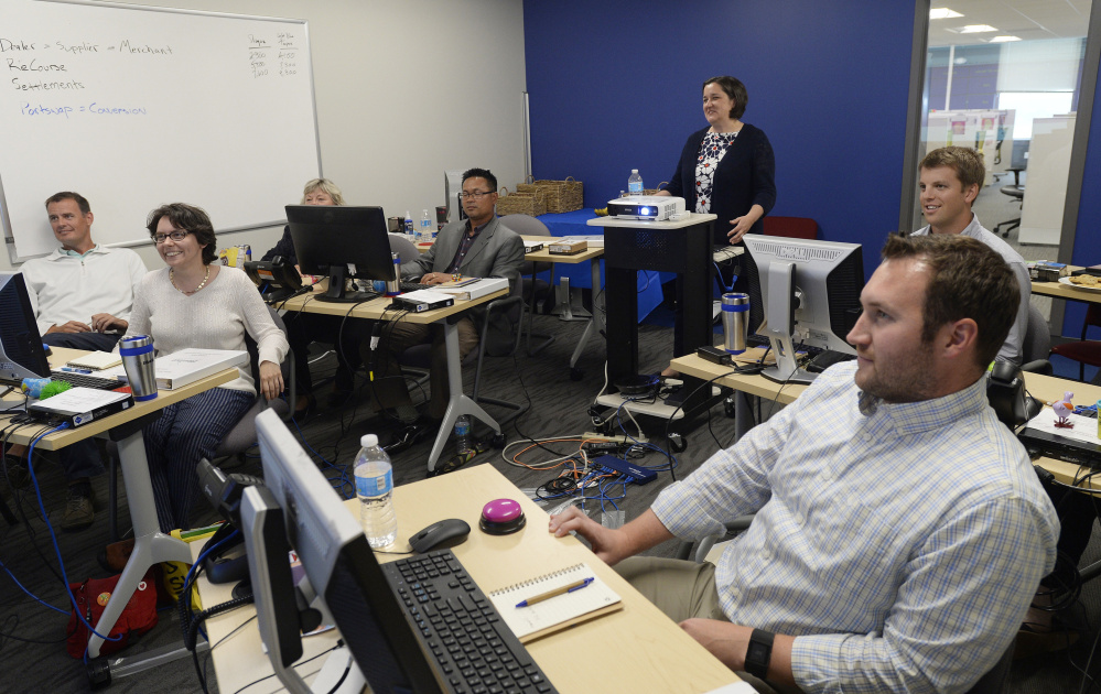 Training and development manager Amy Kavanaugh, back center, leads a training group Thursday at BlueTarp Financial in Portland.