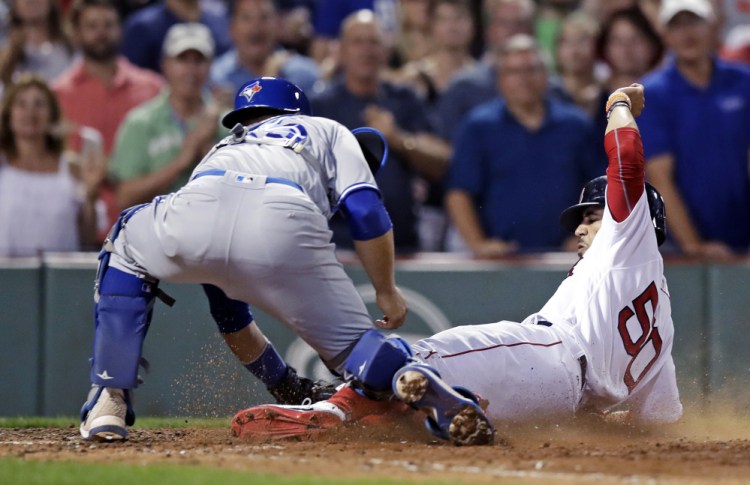 Toronto catcher Russell Martin tags out Mookie Betts, who was trying to score the go-ahead run on a single by Dustin Pedroia in the seventh inning Monday night at Fenway Park. Toronto went ahead in the next inning and held on for a 4-3 win.