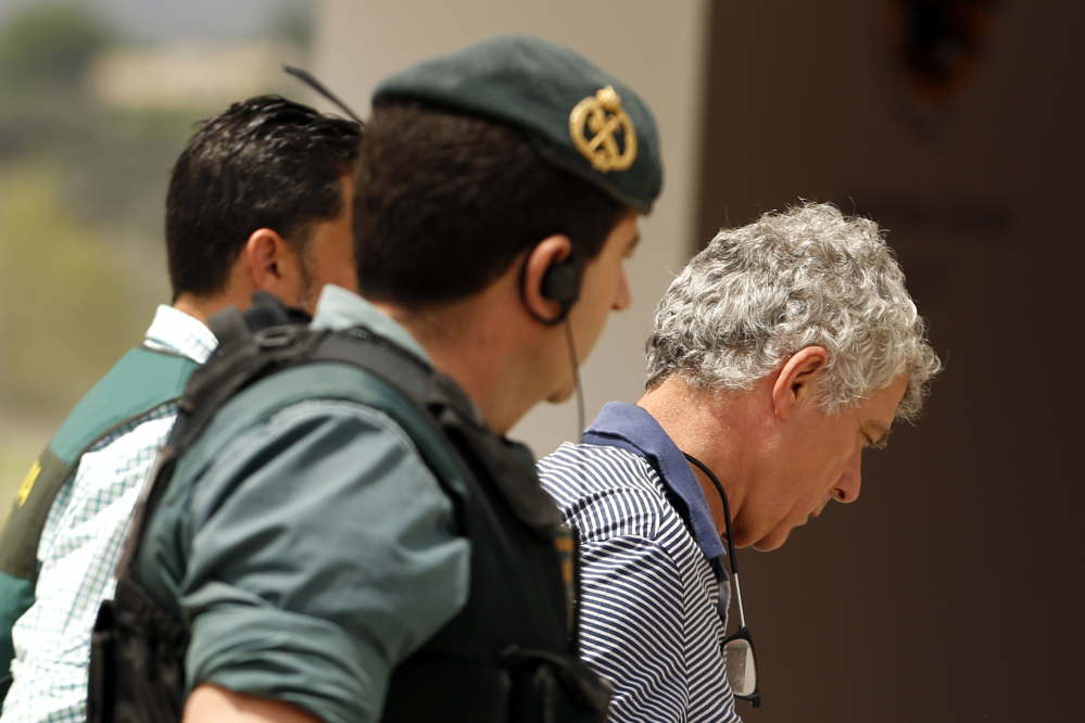 Former President of the Spanish Football Federation Angel Maria Villar, right, is led by Spanish Civil Guard policeman to enter Federation headquarters during an anti-corruption operation in Las Rozas, outside Madrid on Tuesday.