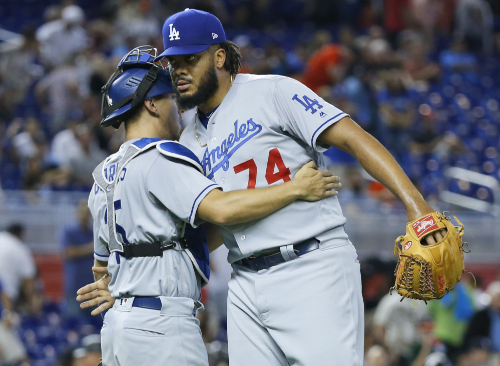 Closer Kenley Jansen gets congratulated by catcher Austin Barnes on Sunday in Miami after the Los Angeles Dodgers won their ninth straight game.
