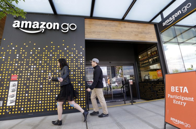 People walk past an Amazon Go store in Seattle last April, where the company is experimenting with new offerings, including Amazon-branded meal kits. The development comes as Amazon is also buying Whole Foods for $13.7 bilion.
