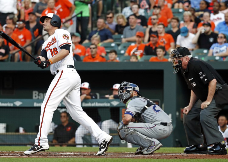 Trey Mancini of the Baltimore Orioles watches his two-run homer head to the stands in front of Texas catcher Jonathan Lucroy and umpire Brian Gorman during the Orioles' 12-1 victory Tuesday.
