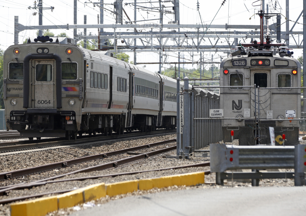 A New Jersey Transit train, left, passes by the sidelined Princeton Dinky train, right, Tuesday, in West Windsor, N.J. Some trains, including the Dinky, were canceled this week during summerlong repair work at New York's Penn Station, the nation's busiest train station.