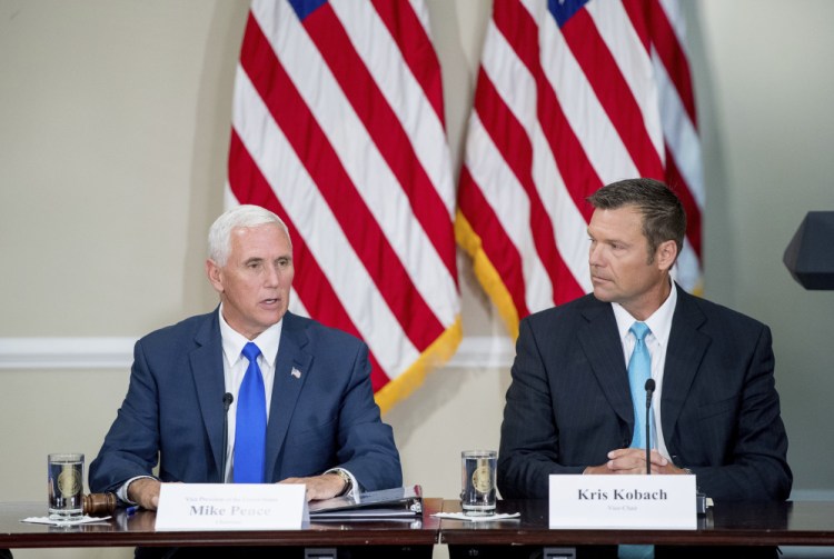 Vice President Mike Pence, left, with Kansas Secretary of State Kris Kobach, speaks during the meeting of the president's voter fraud panel in July.