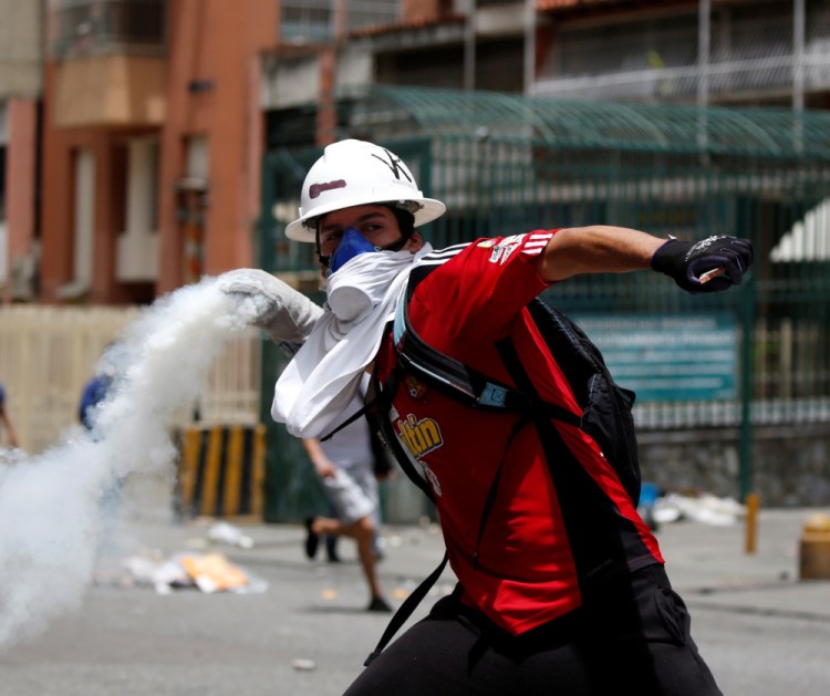 Demonstrators in Caracas clash with riot security forces while participating in a strike called to protest against Venezuelan President Nicolas Maduro.