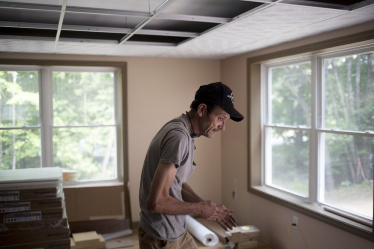 Joe St. Pierre walks through the living room of his new home in Chesterville after a day of helping volunteers work on putting the finishing touches on it. 