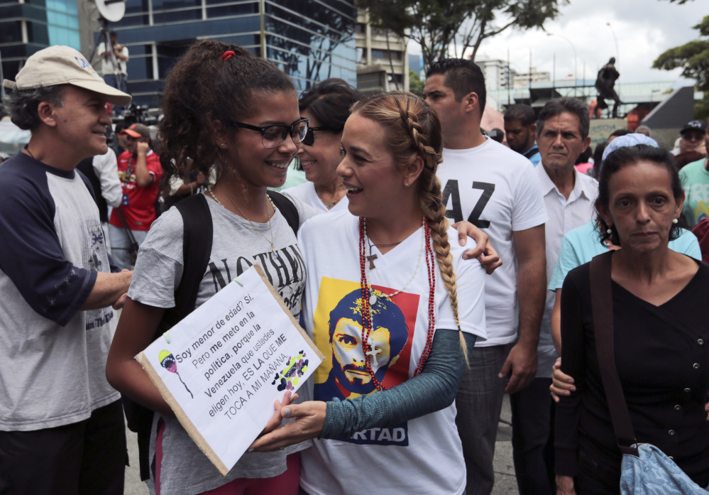 Lilian Tintori, right center, wife of opposition leader Leopoldo Lopez, greets an anti-government protester at a march to the Supreme Court in Caracas on Saturday.