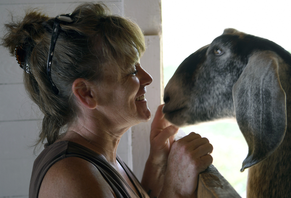 Jackie Frost greets one of her goats Sunday on Open Farm Day at Butting Heads Farm.